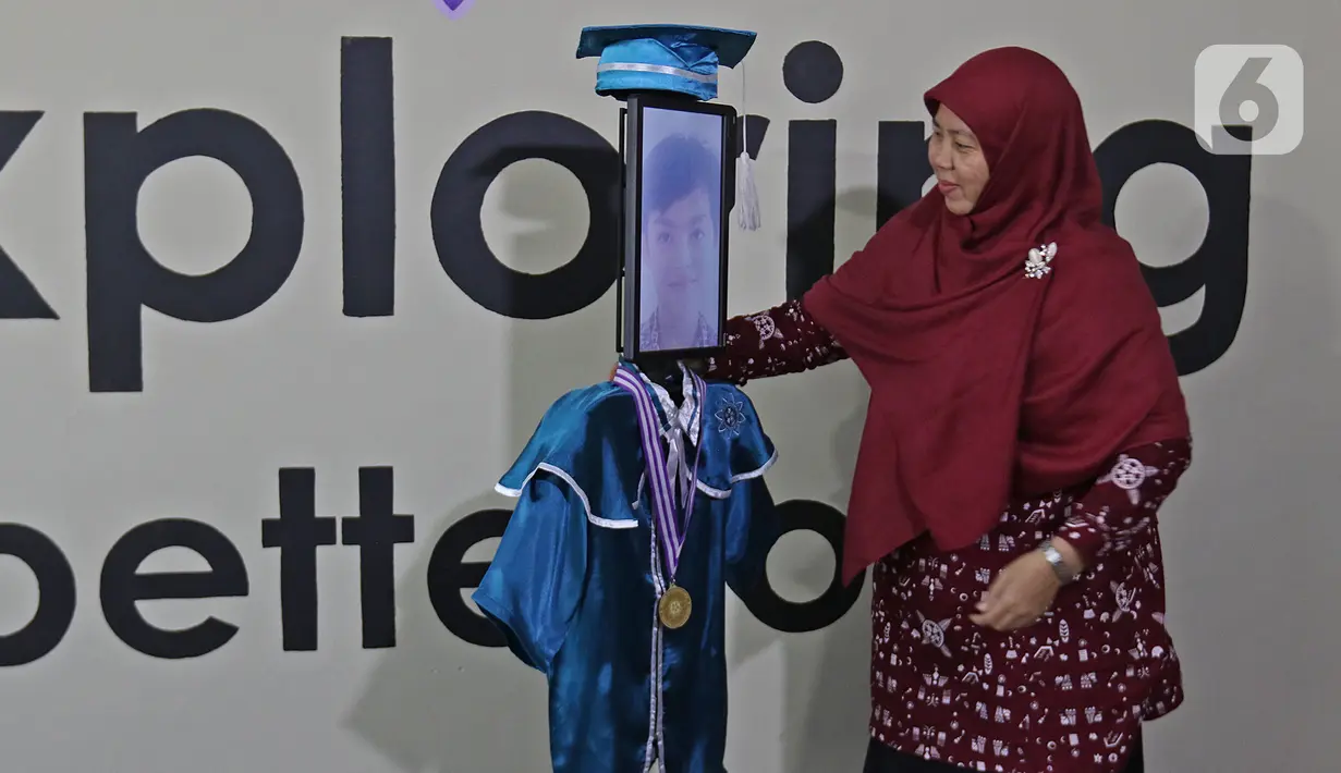 Kepala Sekolah mengalungkan piagam wisuda kepada siswa Kelompok Bermain Taman Kanak-kanak (KB TK) Sekolah Nasional Satu (Nassa School) di Bekasi, Rabu (1/07/2020). Sekolah itu menggunakan teknologi virtual dan roboda guna memudahkan prosesi wisuda di tengah Covid-19. (Liputan6.com/Herman Zakharia)