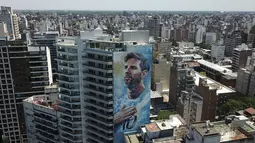Mural pemain sepak bola Lionel Messi menutupi sebuah bangunan di Rosario, Argentina, Rabu (14/12/2022). Kota yang terletak sekitar 300 mil dari ibu kota Argentina, Buenos Aires ini merupakan kota terpadat ketiga di negara itu. (AP Photo/Rodrigo Abd)