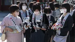 Pemilik robot anjing "aibo" menunggu untuk melanjutkan ke aula kuil untuk menandai Festival Shichi-Go-San di Kuil Kanda Myojin, Tokyo, Jepang, Jumat (11/11/2022). Lebih dari 60 pemilik "aibo" menghadiri acara tradisional yang diadakan setiap tahun dengan mendoakan kesehatan yang baik di masa depan untuk anak perempuan berusia tiga dan tujuh tahun dan anak laki-laki berusia lima tahun. (Richard A. Brooks / AFP)