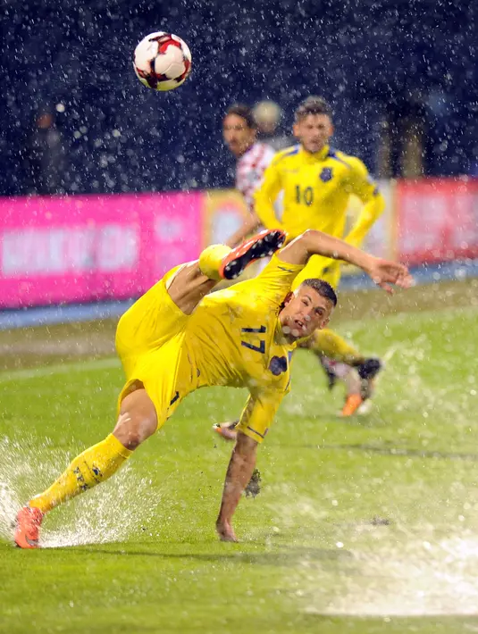 Pemain Kosovo, Benjamin Kololli menendang bola diatas lapangan penuh genangan air pada laga Grup I kualifikasi Piala Dunia 2018 di Stadion Maksimir, Zagreb, (2/9/2017).  Laga tersebut diberhentikan wasit karena stadion penuh genangan air. (AFP/ STR)