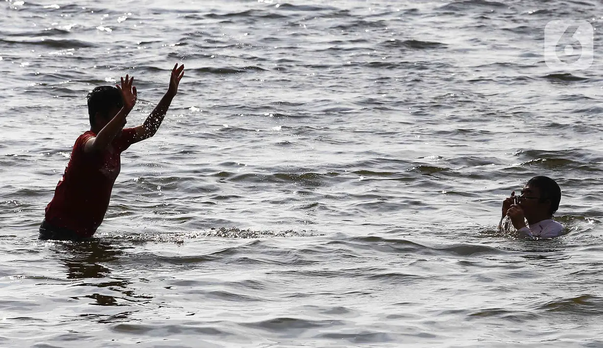 Warga berenang di Pantai Ancol, Pademangan, Jakarta Utara, Rabu (1/6/2022). Libur Nasional Hari Lahir Pancasila, dimanfaatkan warga mengajak sanak saudara tamasya di Pantai Ancol. (Liputan6.com/Herman Zakharia)