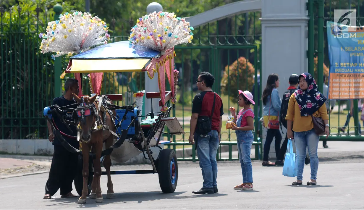 Warga bersiap menaiki delman hias di sekitar Silang Merdeka Barat Daya, Jakarta, Selasa (19/6). Masa libur Lebaran 2018 dimanfaatkan warga untuk berwisata di sekitar Monumen Nasional dengan menaiki delman hias. (Liputan6.com/Helmi Fithriansyah)