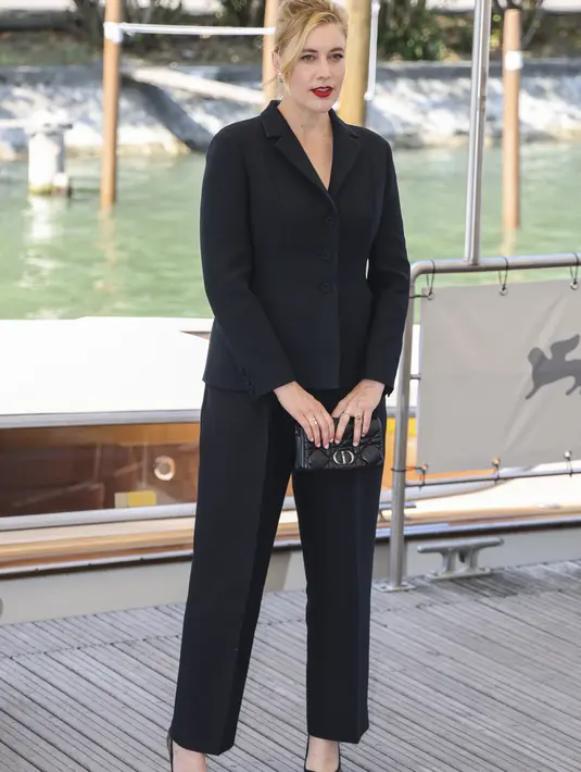 Greta Gerwig berpose untuk fotografer saat tiba untuk sesi pemotretan film 'White Noise' selama Festival Film Venesia edisi ke-79 di Venesia, Italia, Rabu (31/8/2022). Ia juga tampil memesona dengan rambut dikuncir serta lipstik merah. (Photo by Vianney Le Caer/Invision/AP)