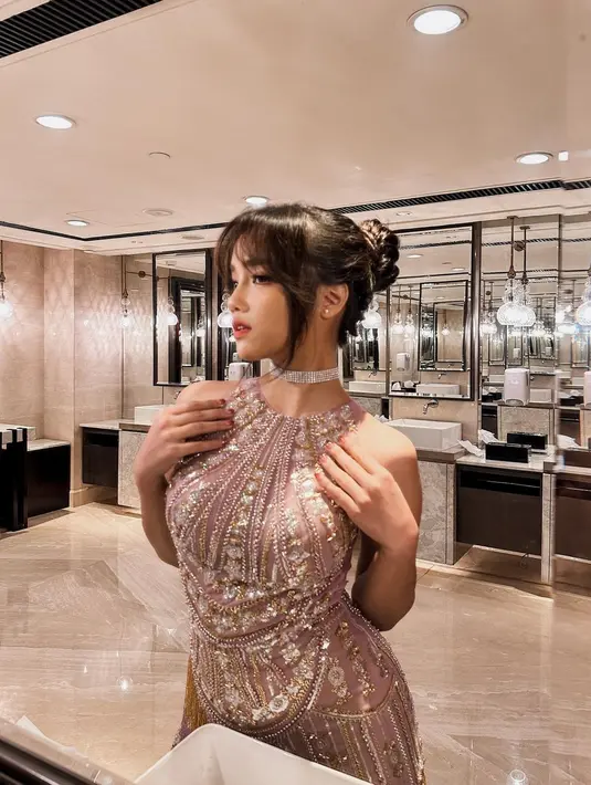 Fuji tampil tak kalah menawan. Ia mengenakan mini dress bertabur batu dan payet yang berkilauan. Makeupnya bernuansa merah muda yang menyempurnakan penampilannya secara keseluruhan. Rambutnya dicepol ke atas menyisakan beberapa bagian rambut sebagai poni yang membingkai wajahnya dengan sempurna. [Foto: Instagram/fuji_an]