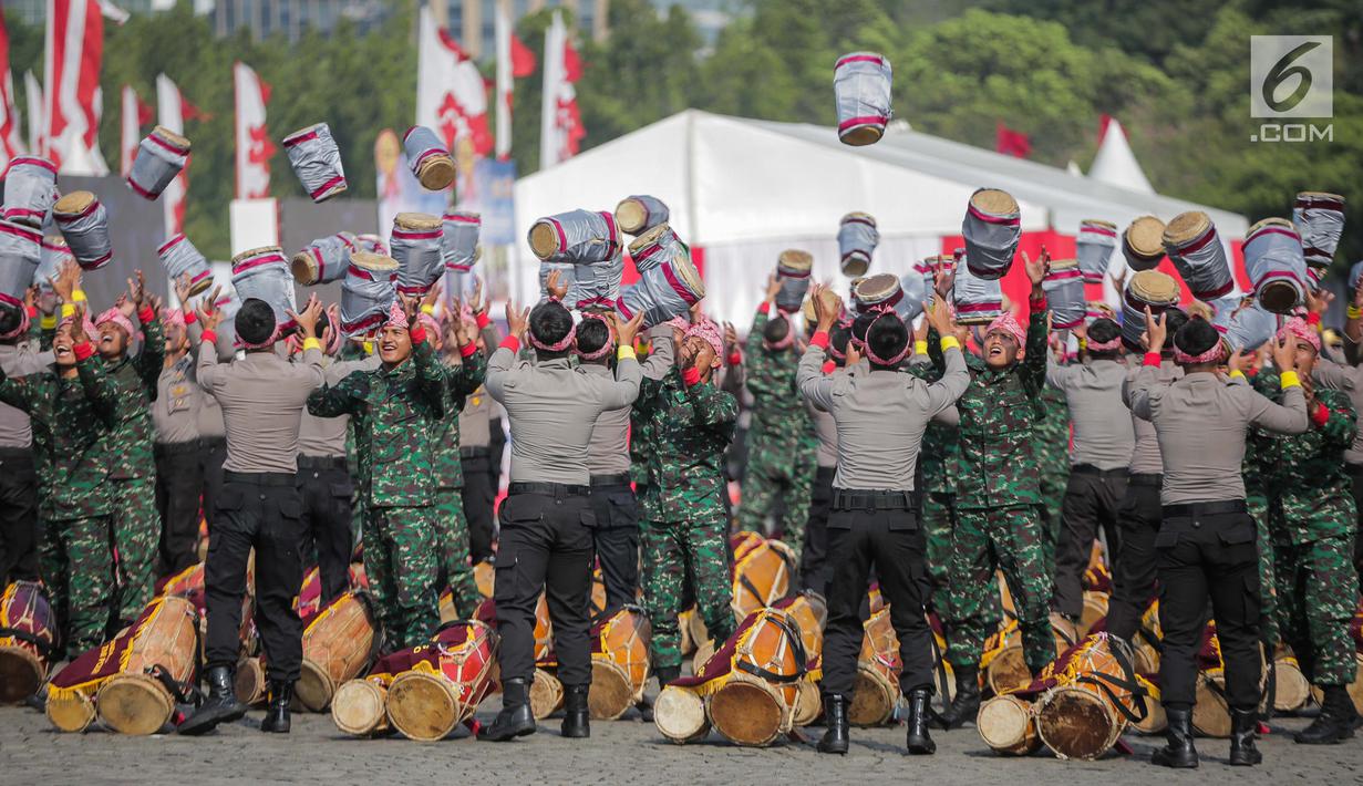 Prajurit TNI dan Polri berkolaborasi memainkan rampak gendang dalam HUT ke-73 Bhayangkara di Monas, Jakarta, Rabu (10/7/2019). HUT Bhayangkara ke-73 ini bertemakan ‘Dengan semangat Promoter, pengabdian Polri, untuk masyarakat, bangsa, dan negara. (Liputan6.com/Faizal Fanani)