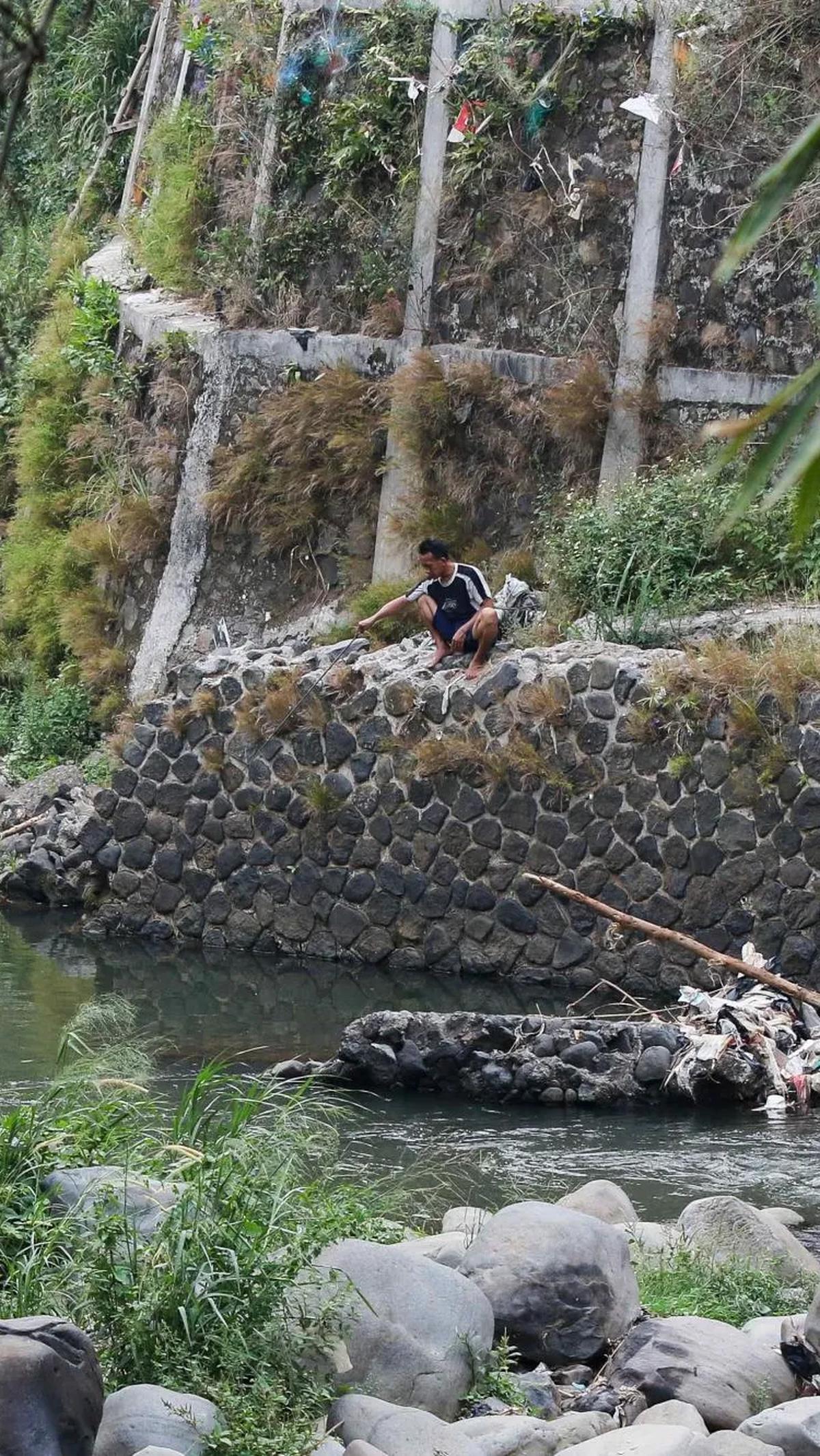 Seorang warga sedang asyik memancing di aliran sungai Ciliwung yang surut saat musim kemarau di kawasan Pulo Geulis Kota Bogor.