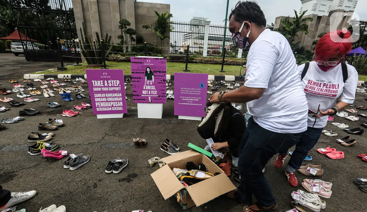 Pegiat komnas perempuan merapikan sepatu saat aksi diam 500 Langkah Awal Sahkan RUU PKS di depan gedung DPR, Jakarta, Rabu (25/11/2020). Dalam aksinya mereka menyusun sepatu sebagai simbol "semua peduli, semua terlindungi, stop sexual violence". (Liputan6.com/Johan Tallo)