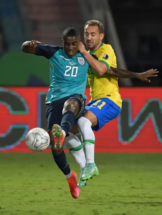 Gelandang timnas Ekuador, Jhegson Mendez dan gelandang Brasil Philippe Coutinho berebut bola pada laga Grup B Copa America 2021 di Estadio Olimpico Pedro Ludovico, Senin (28/6/2021). Laga antara Brasil vs Ekuador berakhir imbang 1-1, Ekuador pun lolos ke babak perempat final. (NELSON ALMEIDA/AFP)