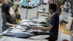 Pedagang ikan bandeng melayani pembeli di kawasan Rawa Belong, Jakarta, Selasa (21/1/2020). Bandeng yang biasanya menjadi hidangan khas saat Tahun Baru Imlek tersebut mulai ramai diperdagangkan di Rawa Belong. (Liputan.com/Faizal Fanani)