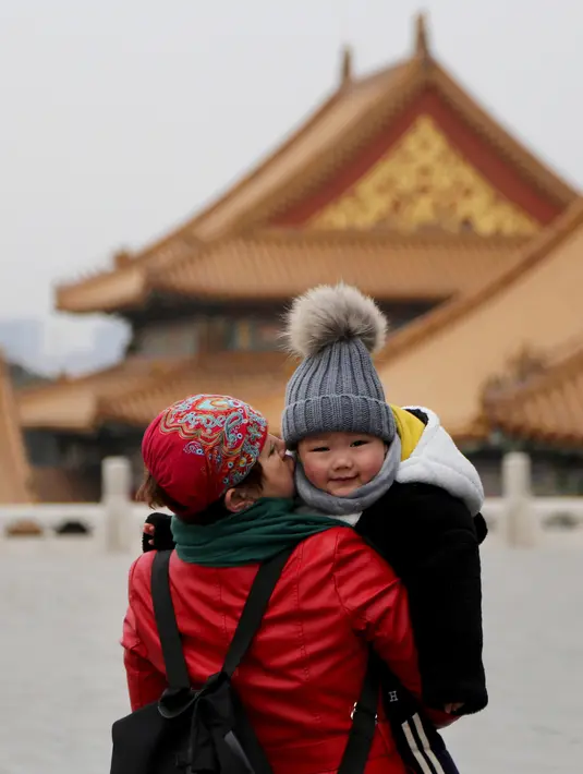 Seorang anak tersenyum saat melakukan tur ke Kota Terlarang di Beijing, (7/3). Kota Terlarang, merupakan istana terisolasi kaisar Qing dan Dinasti Ming China untuk tempat wisata utama yang terletak di pusat ibu kota. (AP Photo/Aijaz Rahi)