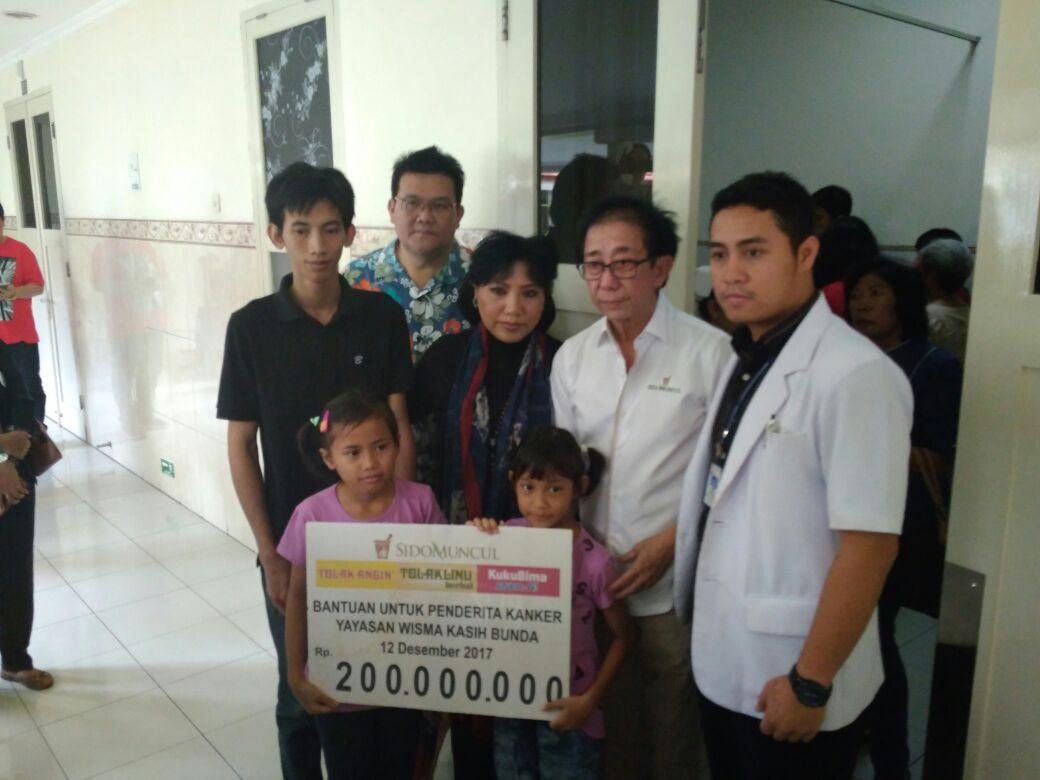 Direktur PT Sido Muncul Tbk, Irwan Hidayat menyerahkan bantuan pengobatan Rp 200 juta kepada Intan Guswanti, penderita kanker stadium akhir. (foto :Liputan6.com/edhie prayitno ige)