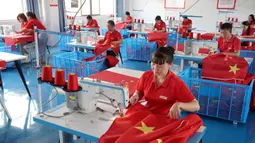 Para pekerja membuat bendera nasional di sebuah pabrik menjelang Hari Nasional di Wuyi, Provinsi Zhejiang, China, 28 September 2021. Hari Nasional adalah sebuah hari libur nasional di China untuk merayakan hari kebangsaan mereka dan diperingati pada tanggal 1 Oktober setiap tahun. (STR/AFP)
