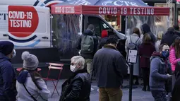 Orang-orang mengantre di tempat pengujian COVID-19 di Times Square, New York, Senin (13/12/2021). Wajib masker di semua tempat umum dalam ruangan di negara bagian New York mulai berlaku pada Senin ketika para pejabat menghadapi lonjakan kasus COVID-19 dan rawat inap. (AP Photo/Seth Wenig)