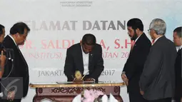 Saldi Isra (tengah) menandatangani pakta integritas saat penyambutan di Jakarta, Selasa (11/4). Saldi Isra menjadi Hakim MK menggantikan Patrialis Akbar yang tersandung kasus dugaan penyuapan. (Liputan6.com/Helmi Fithriansyah)