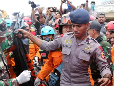 Tim SAR mengevakuasi jenazah korban gempa dari reruntuhan Masjid Jamiul Jamaah di Bangsal, Lombok Utara, Rabu (8/8). Berdasarkan kesaksian warga, diduga puluhan korban yang sedang melaksanakan pengajian tertimbun bangunan masjid. (AP/Tatan Syuflana)