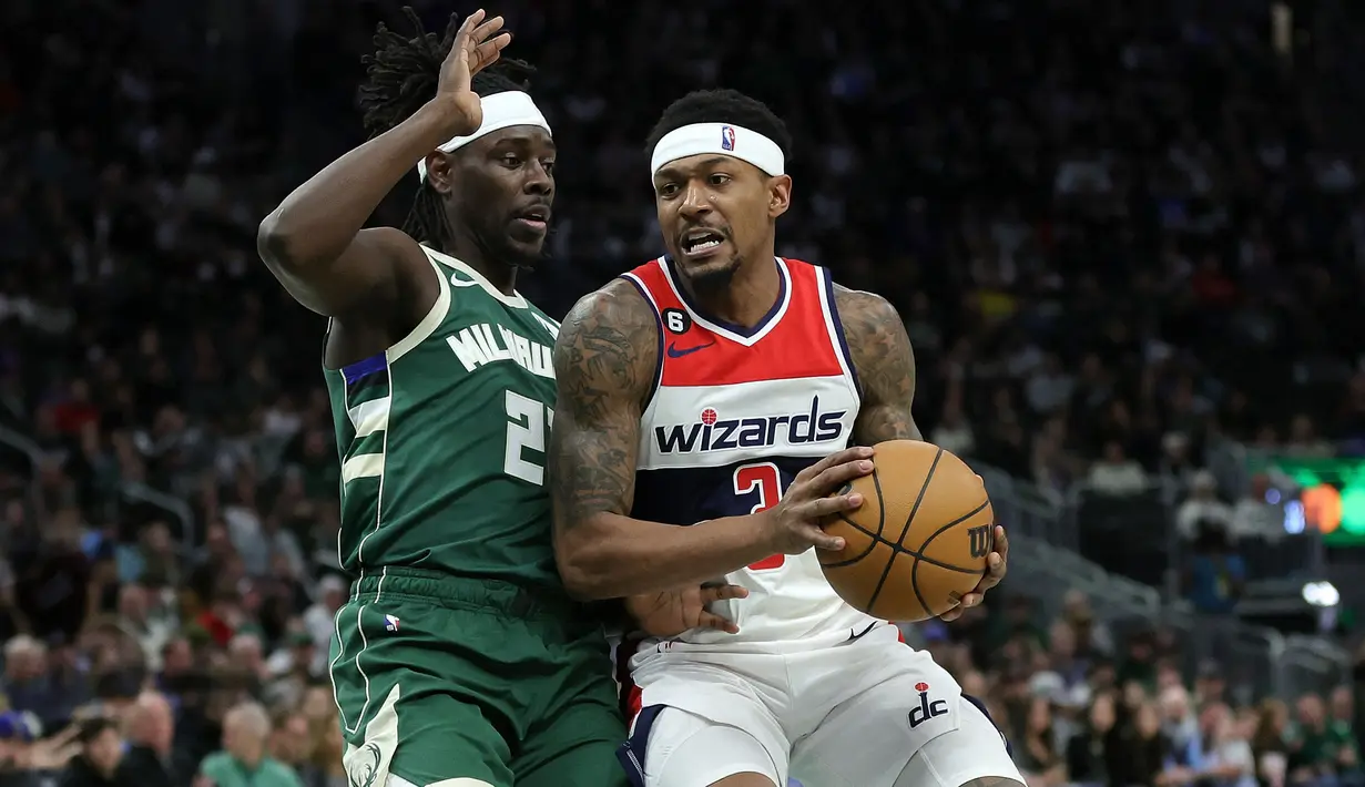 Pebasket Washington Wizards, Kristaps Porzingis (kanan) berebut bola dengan pebasket Milwaukee Bucks, Jrue Holiday pada laga yang berlangsung di Fiserv Forum, Milwaukee, Wisconsin, 3 Januari 2023.  Prozingis berpotensi akan memperkuat Timnas Basket Latvia pada Grup H di Piala Dunia Basket 2023. Sementara itu, Latvia akan menjalani debut pada ajang tersebut. (AFP/Getty Images/Stacy Revere)