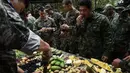 Marinir Thailand dan AS memakan buah dan sayuran yang berada di hutan saat latihan gabungan Cobra Gold antara militer AS dan Thailand di Chonburi, Thailand (19/2). (AFP Photo/Lilian Suwanrumpha)