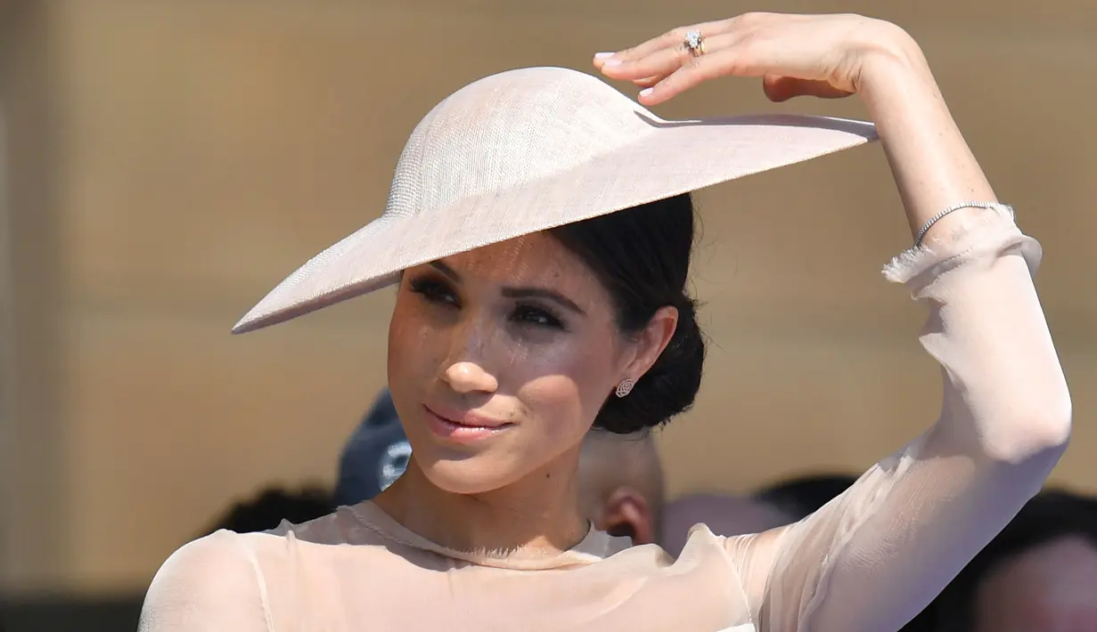 Duchess of Sussex, Meghan Markle menghadiri pesta kebun Istana Buckingham di London, Selasa (22/5). Tiga hari setelah pernikahannya dengan Pangeran Harry, Meghan tampil perdana di depan publik bersama sang suami. (Dominic Lipinski/Pool Photo via AP)
