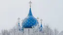 Pemandangan atap gereja yang dikelilingi pohon tertutup salju di desa wisata Suzdal, Rusia (23/1). Suzdal merupakan daerah bersejarah yang menjadi satu pemukiman tertua di Rusia. (AFP Photo/Mladen Antonov)