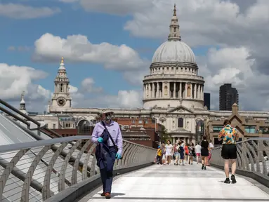 Orang-orang berjalan di Jembatan Milenium dengan latar pemandangan Katedral St. Paul di London, Inggris, 1 Agustus 2020. Pemerintah Inggris pada Jumat (31/7) mengumumkan penundaan pelonggaran beberapa langkah pembatasan menyusul jumlah infeksi virus corona yang meningkat. (Xinhua/Han Yan)