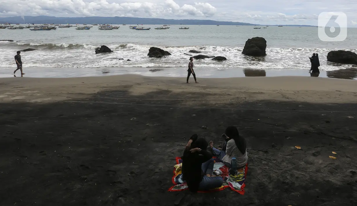 Warga bersantai di Pantai Pelabuhan Ratu, Kabupaten Sukabumi, Jawa Barat, Jumat (12/11/2021). Pantai Pelabuhan Ratu menjadi tempat wisata favorit warga Jawa Barat serta Jakarta dan sekitarnya. (Liputan6.com/Johan Tallo)