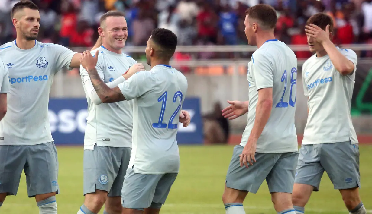 Striker Everton, Wayne Rooney mendapat ucapan selamat dari rekan setimnya usai mencetak gol ke gawang Gor Mahia pada pertandingan persahabatan di Tanzania, Kamis (13/7).  Rooney langsung mencetak gol dalam debutnya bersama Everton. (AP Photo/Khalfan Said)