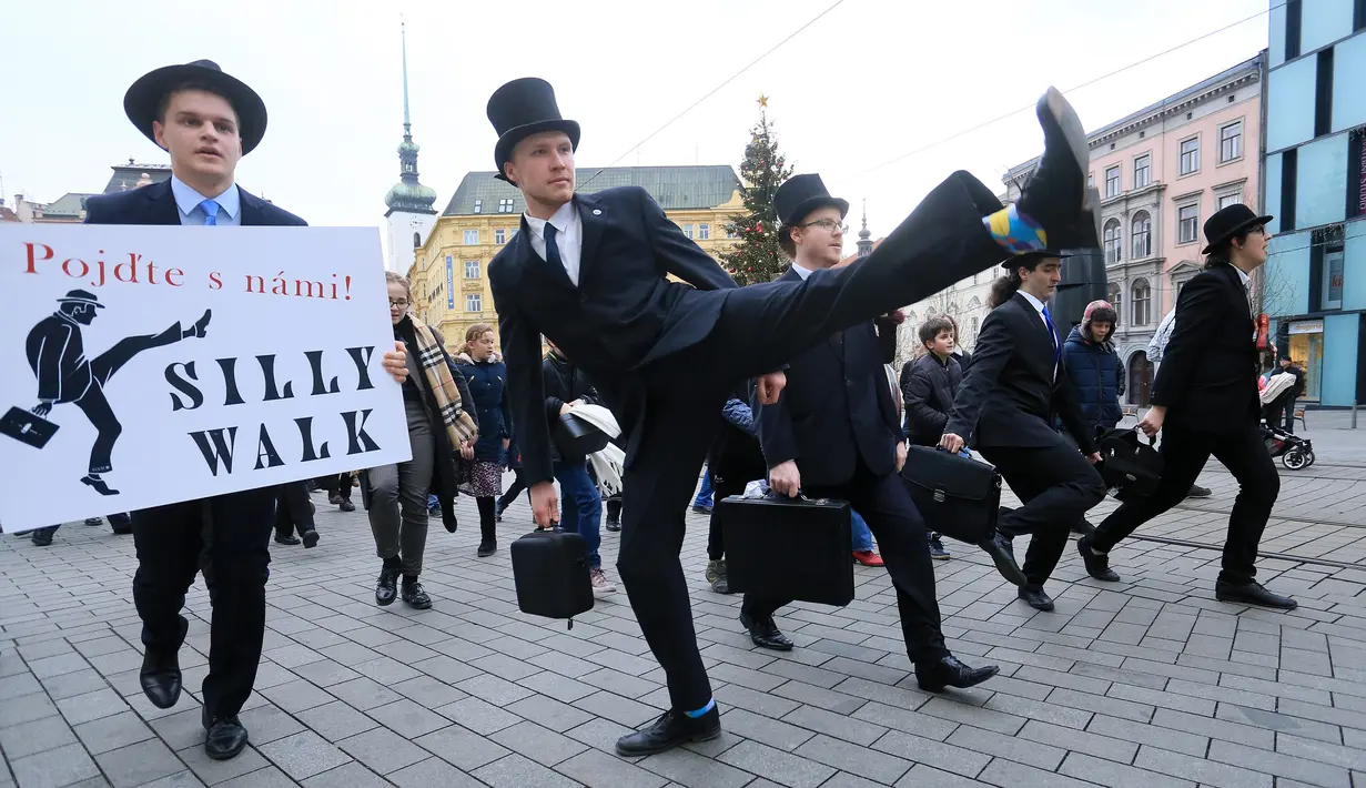 Seorang pria mengenakan kostum berjalan dengan mengangkat tinggi kakinya di Brno, Republik Ceko (7/1). Mereka mengenakan kostum tersebut untuk mengenang grup komedi asal Inggris, Monty Python. (AFP Photo/Radek Mica)