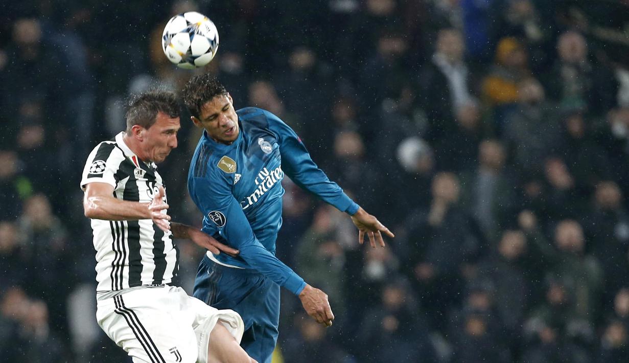 Bek Real Madrid, Raphael Varane, duel udara dengan striker Juventus, Mario Mandzukic, pada laga Liga Champions di Stadion Allianz, Selasa (3/4/2018). Juventus takluk 0-3 dari Real Madrid. (AP/Antonio Calanni)