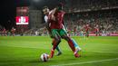 Bek Portugal Nuno Mendes (kanan) bersaing dengan gelandang Luksemburg Danel Sinani pada lanjutan Kualifikasi Piala Dunia 2022 di Stadion Do Algarve, Rabu (13/10/2021) dini hari WIB. Hat-trick Cristiano Ronaldo membuat Portugal menang 5-0 atas Luksemburg. (CARLOS COSTA / AFP)