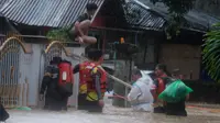 Sejumlah personel Samapta Polda Sulut melakukan evakuasi warga yang terjebak banjir di Kelurahan Ternate Tanjung, Kecamatan Singkil, Kota Manado, Jumat (27/1/2023).