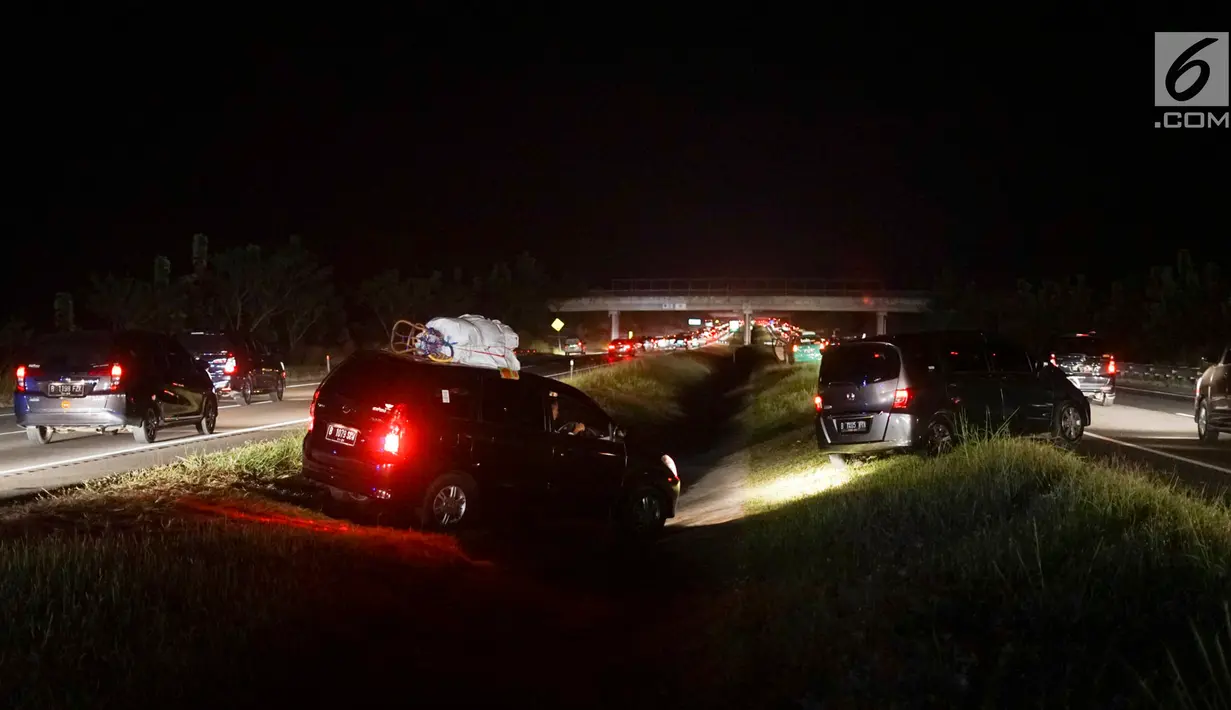 Sejumlah kendaraan yang didominasi pemudik menerobos parit pembatas untuk pindah jalur di Jalan Tol Cikopo - Palimanan KM 135, Jawa Barat, Sabtu (8/6/2019). Padatnya arus balik di ruas tol itu membuat sebagian pengemudi berpindah jalur untuk menghindari kemacetan. (Liputan6.com/Immanuel Antonius)