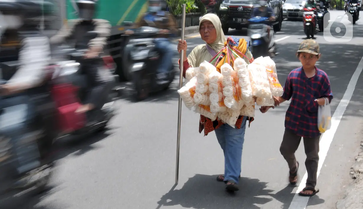<p>Penyandang tunanetra Ibu Adel (48) berjalan bersama anak bungsunya menyusuri jalan raya Ciputat, Tangerang Selatan, Selasa (26/04/20222). Warga Pondok Cabe 3 ini setiap harinya menyusuri jalan hingga sekitar 10 km menjajakan kerupuk Bangka yang dijualnya Rp 25 ribu/bungkus. Sudah beberapa bulan terakhir ini ia mengaku pendapatannya merosot drastis hanya sekitar Rp 50 ribu/ hari yang digunakan untuk mencukupi kebutuhan sehari-hari. (merdeka.com/Arie Basuki)</p>