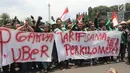 Sejumlah pengemudi ojek online membentangkan spanduk saat menggelar aksi di seberang Istana Merdeka, Jakarta, Selasa (27/3). Mereka juga meminta legalitas angkutan ojek online. (Liputan6.com/Arya Manggala)