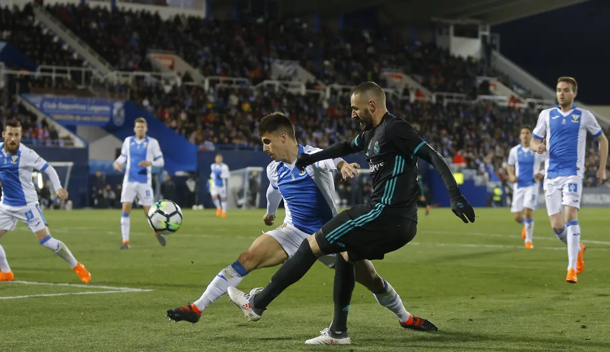 Karim Benzema (kanan) melepaskan tembakan ke gawang Leganes saat diadang Unai Bustinza pada lanjutan La Liga Santander di Butarque stadium, Leganes, (21/2/2018). Real Madrid menang 3-1.  (AP/Francisco Seco)