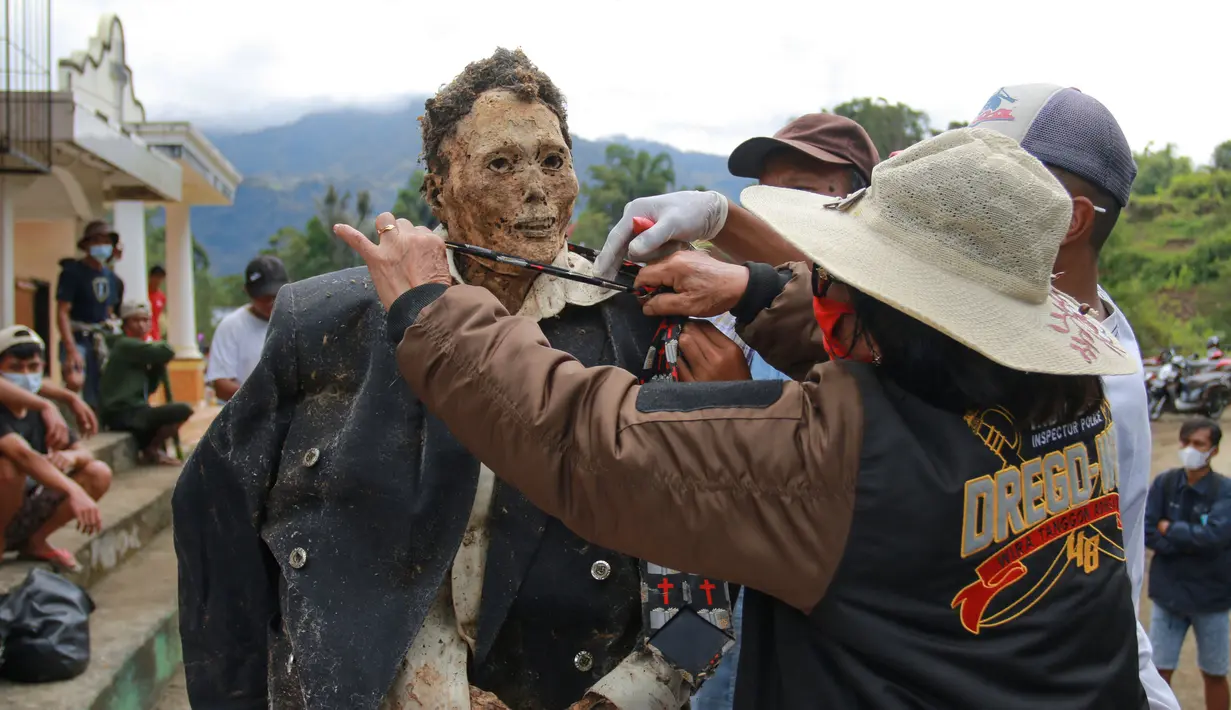 Keluarga melakukan ritual adat Manene di Desa Pangala, Toraja Utara, Sulawesi Selatan, 27 Agustus 2021. Manene merupakan upacara turun temurun masyarakat Toraja sebagai bentuk penghormatan kepada leluhur mereka yang telah wafat. (SEVIANTO PAKIDING/AFP)