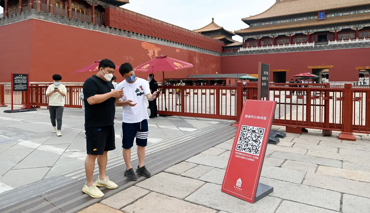 <p>Orang-orang menggunakan ponsel untuk memindai kode kesehatan di pintu masuk Kota Terlarang di Beijing sebelum kunjungan mereka setelah pemerintah melonggarkan beberapa pembatasan Covid-19, Selasa (7/6/2022). Pengunjung mulai kembali ke restoran di sebagian besar wilayah Beijing untuk pertama kalinya dalam lebih dari sebulan pada Senin, 6 Juni 2022. (WANG Zhao / AFP)</p>