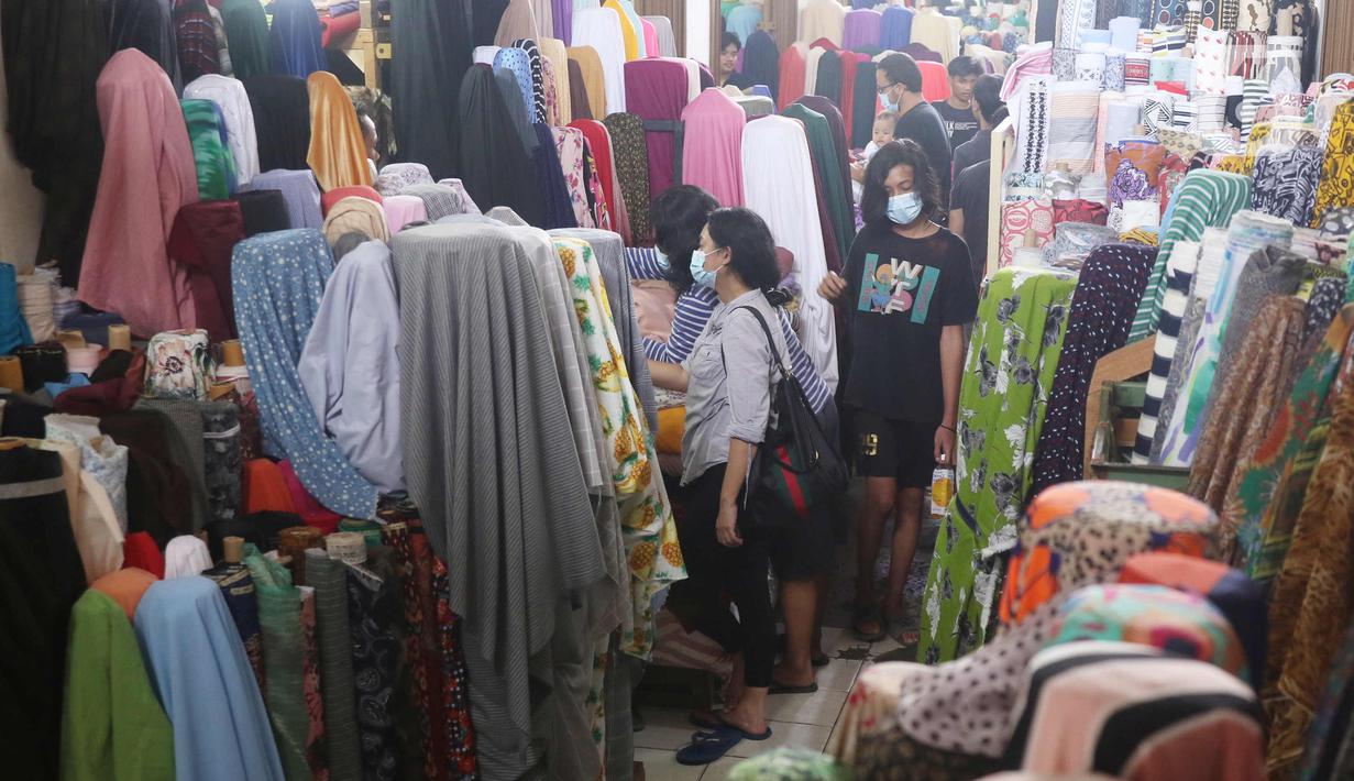Calon pembeli memilih kain di Pasar Cipadu, Tangerang, Selasa (2/3/2021). Pandemi Covid-19 membuat industri tekstil dan pakaian jadi mengalami pertumbuhan negatif 8, 8 persen sepanjang 2020 dengan kinerja ekspor yang berkontraksi 17 persen. (Liputan6.com/Angga Yuniar)