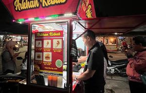 Samuri (58) sedang melayani pelanggan di tempat usahanya Arkhan Kebab