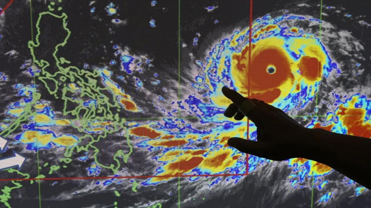 Petugas meteorologi Filipina sedang menunjukkan pergerakan Topan Mangkhut (AP)