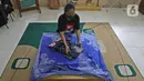 Perajin menyelesaikan salah satu tahapan produksi batik Marunda di Rusunawa Marunda, Jakarta, Selasa (14/7/2020). Batik Marunda memiliki pelanggan tetap yang kerap memesan atau secara online. (Liputan6.com/Herman Zakharia)