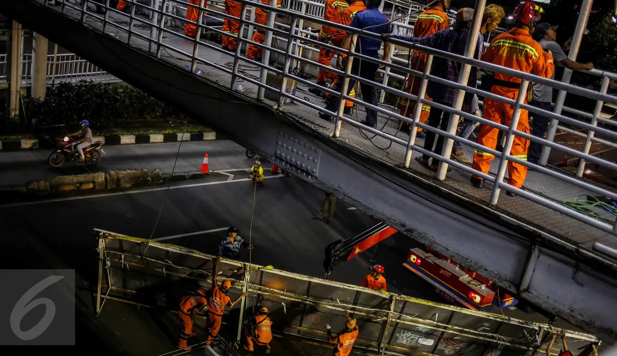 Para pekerja membongkar papan reklame yang terpasang di dinding JPO kawasan Salemba, Jakarta, Rabu (26/10) malam. Pembongkaran dalam rangka penertiban terpadu yang dilakukan oleh petugas gabungan dari Pemprov DKI Jakarta. (Liputan6.com/Faizal Fanani)