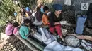Sejumlah pekerja perempuan membawa anak mereka saat bekerja mengupas buah aren di Kampung Citugu, Desa Puraseda, Leuwiliang, Kabupaten Bogor, Jawa Barat, Minggu (25/4/2021). Kolang-kaling dari petani dibanderol ke tengkulak dengan harga Rp 6.000-Rp 9.000 per kilogram. (merdeka.com/Iqbal S. Nugroho)