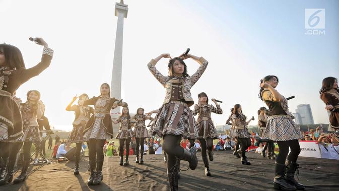 Aksi para personel girlband JKT48 saat tampil dalam puncak Kirab Obor Asian Games 2018 di Monas, Jakarta, Sabtu (18/8). Obor Asian Games 2018 diarak dari Monumen Nasional (Monas) menuju Stadion Utama Gelora Bung Karno (SUGBK). (Liputan6.com/Faizal Fanani)