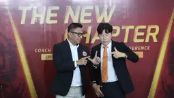 Presiden Persija Jakarta, Mohamad Prapanca, mengajarkan Shin Tae-yong untuk membentuk simbol The Jakmania dalam konferensi pers di Jakarta International Stadoum (JIS), Jakarta Utara, pada Senin (8/6/2026). (Bola.com/M Iqbal Ichsan)