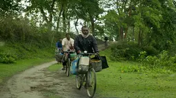 Nelayan mengendarai sepeda untuk membeli ikan di tepi sungai Brahmaputra, India (3/4). Assam sangat kaya akan sumber daya airnya. Brahmaputra adalah salah satu sungai terbesar di Asia, yang melewati wilayah China Tibet, India dan Bangladesh sebelum konvergen ke Teluk Benggala. (AP Photo/Anupam Nath)