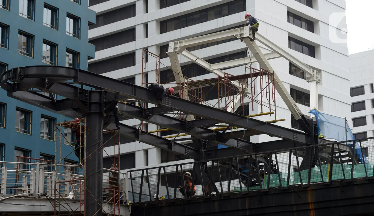 Pekerja menyelesaikan proyek Tugu Tenaga Kesehatan di Jembatan Penyeberangan Orang (JPO) Sudirman, Jakarta, Jumat (12/11/2021). Pembangunan Tugu Tenaga Kesehatan juga sebagai revitalisasi jembatan antara pejalan kaki, pesepeda, dan pengguna transportasi publik. (merdeka.com/Imam Buhori)