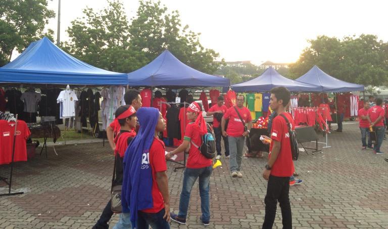 Para pedagang atribut mendapat berkah dengan kehadiran para suporter timnas Indonesia yang ingin menonton laga kontra Filipina pada SEA Games 2017 di Stadion Shah Alam, Selangor, Kamis (17/8/2017). (Bola.com/Benediktus Gerendo Pradigdo)
