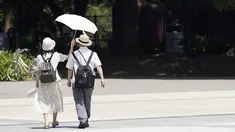 Orang-orang berbagi payung di bawah terik matahari di Taman Ueno, Selasa, di Tokyo pada 11 Juli 2023. (AP Photo/Eugene Hoshiko)