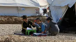 Anak-anak pengungsi Irak terlihat tetap belajar di kamp Khazer, Irak (5/12). Mereka melarikan diri akibat konflik peperangan antara pasukan koalisi Irak dengan ISIS. (REUTERS / Alaa Al-Marjani)