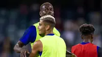 Gelandang Manchester United, Paul Pogba berbincang dengan rekannya Andreas Pereira selama sesi latihan terbuka jelang pertandingan tur pramusim melawan Perth Glory di Stadion Optus, Perth (11/7/2019). MU dijadwalkan menggelar tur pramusim di Australia, Tiongkok, dan Singapura. (AFP Photo/Tony Ashby)